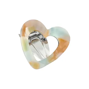 Detail of hollow heart hair clip with rainbow marble texture and silver metal clasp
