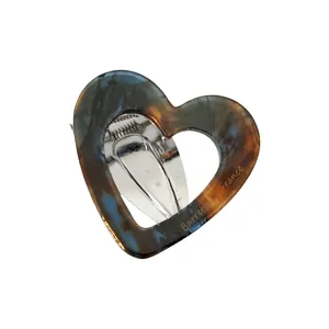 Detail of heart-shaped acetate hair clip with tortoiseshell pattern and metal back clip