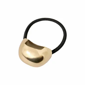 Detailaufnahme von goldenem Metall-Haargummi mit schwarzem elastischem Band