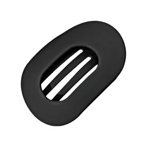 Detalle de la pinza de pelo ovalada en metal negro mate con diseño geométrico hueco