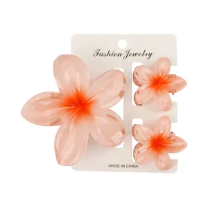 Detailansicht von drei rosa Frangipani-Haarklammern auf einer weißen Displaykarte