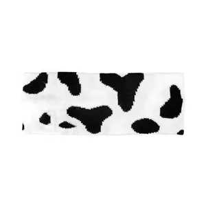 Vue détaillée de la texture tricotée du bandeau avec motif vache noir et blanc