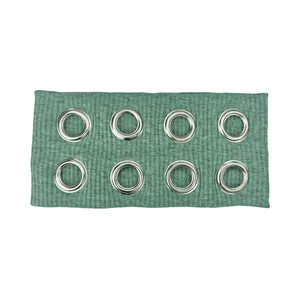 Detail of green ribbed fabric headband featuring double rows of silver metal eyelets