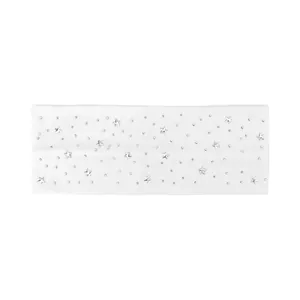 Dettaglio macro della fascia bianca con borchie a stella e strass scintillanti