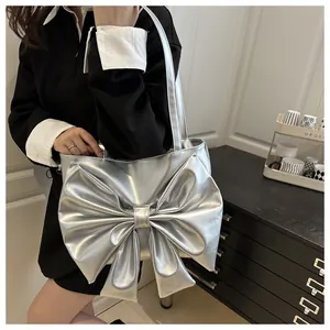 Dettaglio della borsa a spalla argento metallizzato con fiocco grande e tracolla sottile