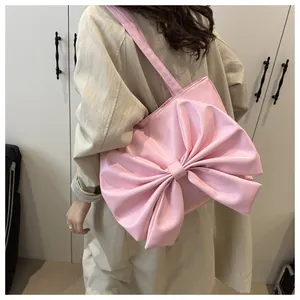 Vista posteriore della modella con borsa rosa e fiocco grande che mostra lo stile