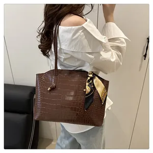 Dettaglio borsa tote marrone effetto coccodrillo con foulard in seta decorativo