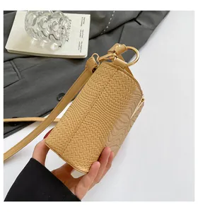Detail shot of beige woven shoulder bag featuring premium texture and gold metal hardware