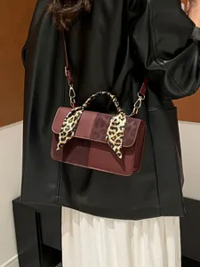 Sac bandoulière bordeaux vintage avec foulard léopard porté par un mannequin