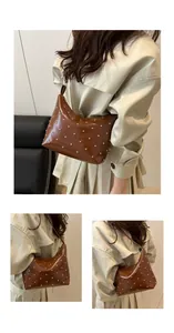 Macro detail of brown patent leather shoulder bag with vintage silver rivet studs