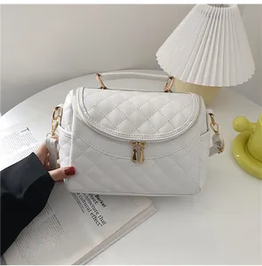 Detailed macro view of white quilted stitching pattern and premium gold metal handle