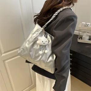 Silver metallic tote bag detail with diamond quilting and braided shoulder strap