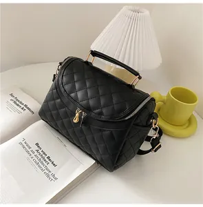 Close-up of black quilted PU leather vanity bag with gold zippers and metal hardware
