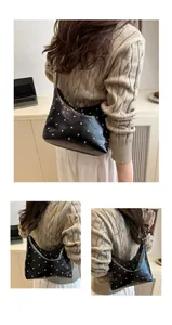Detail of silver rivets on black glossy leather hobo bag with sleek shoulder strap