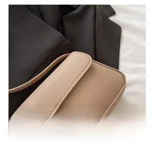 Close-up of beige lychee grain leather handbag with high-quality golden metal lock