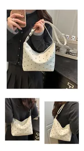 Detail shot of white glossy PU leather hobo bag with silver metallic round rivets