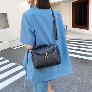 Black quilted crossbody bag with gold hardware shown as hand-held and shoulder bag