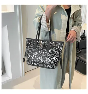 Borsa tote nera casual con motivi graffiti bianchi in un ambiente interno elegante
