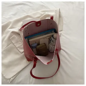 Macro view of red tote bag interior showing large capacity for laptop and daily items