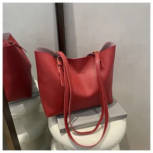 Detail of red matte leather tote bag featuring 'FASHION & BAGS' text and dual straps