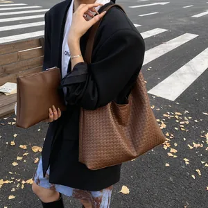Brown woven tote bag and clutch set for women in a street style autumn setting