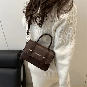 Sac bandoulière en cuir grainé marron foncé avec boucles argentées et poignée haute