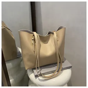 Detail view of khaki large tote bag featuring slim shoulder straps and logo print