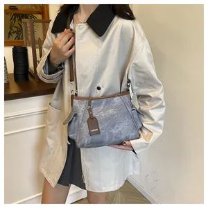 Detail view of the vintage grey-blue canvas bag with brown leather trim and fashion tag