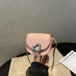 Mini sac selle rose avec boucle coeur argentée et bandoulière en cuir texturé