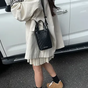 Mini sac à bandoulière noir tissé avec poignées et lanière nouée pour un style chic