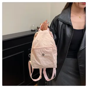 Detail of pink nylon mini backpack featuring pleated texture and silver metal buckle
