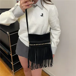 Borsa tote vintage nera con frange e borchie dorate indossata da una modella