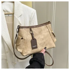 Detail of retro khaki bucket bag with side pockets and brown fashion strap tag