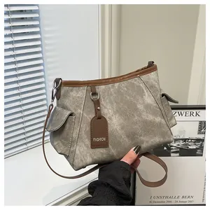 Detail view of the contrast-color bucket bag featuring leather trim and fashion tag