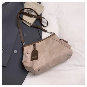 Detail of beige tote bag showing metal feet and fashion tag on premium suit fabric