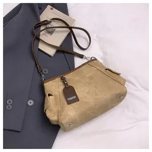 Detailed close-up of the vintage khaki canvas bucket bag with brown leather trim and accents