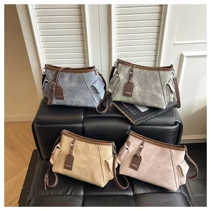 Detail view of four casual crossbody bags in muted tones on a vintage leather bench