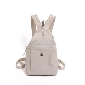 Beige nylon sling backpack with unique triangular shape and adjustable strap for women