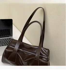 Dettaglio della borsa a spalla marrone scuro vintage in pelle cerata lucida con cerniera