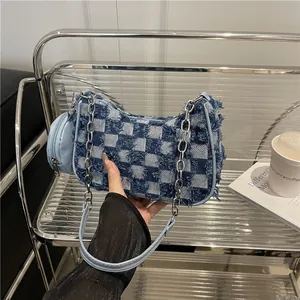 Blue denim checkered underarm bag with frayed edges and silver chain strap