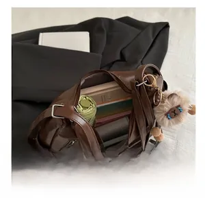 Macro view of brown soft leather tote bag showing large capacity for books and umbrella