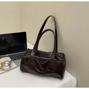 Dettaglio della borsa bowling in pelle lucida cioccolato con dettagli stile baguette