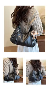 Detail of black vintage soft leather tote bag with tassels and plush lion charm