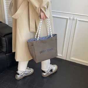 Brown canvas tote bag with thick rope handles and TOTE BAG lettering for daily commute