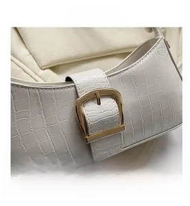 Close-up of white crocodile pattern underarm bag with gold square metal buckle detail