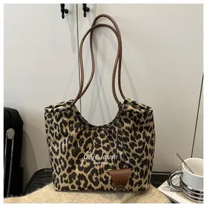 Detail of leopard print suede tote with thin brown leather straps and artistic lettering