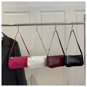 Detailed display of four glossy patent leather baguette bags in purple, white, red, and black