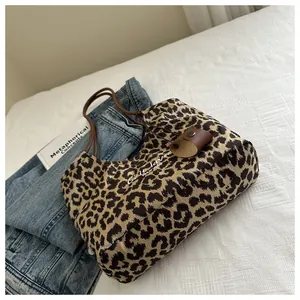 Close-up of leopard print suede tote bag with C'est la vie text and leather charm