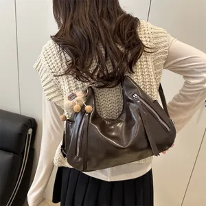 Dark brown faux leather hobo bag with side silver zippers and plush doll charm