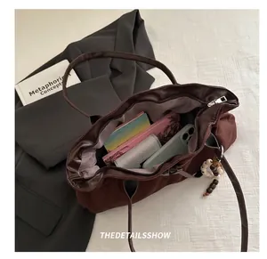 Macro view showing large capacity of dark brown suede tote bag with daily essentials